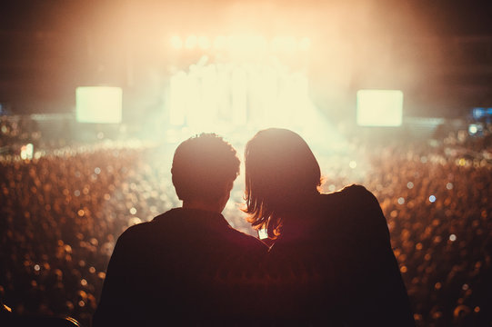 Silhouette of two friends on a rock concert