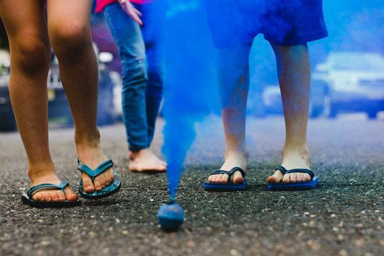 Blue Smoke Bomb in Street With Children Watching