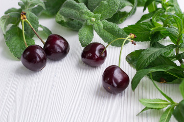 Vinous red cherries, fresh mint and melissa on white wood