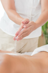Obraz na płótnie Canvas Woman enjoying getting a salt scrub beauty treatment at spa.