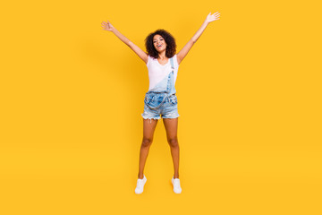Fototapeta na wymiar Full size portrait of funny crazy girl jumping in air holding hands up making star pose looking at camera isolated on yellow background. Luck success achievement concept