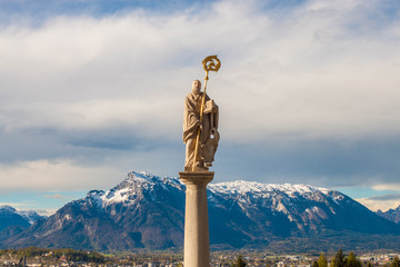 Statue of St.Benedict in front of Maria Plain pilgrimage church in Berghein bei Salzburg, Austria. Untersberg mountain on the background.