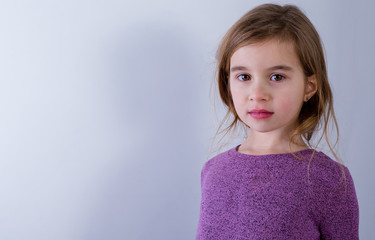 Portrait of young girl wearing violet sweater