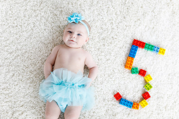 Adorable baby girl on white background wearing turquoise tutu skirt. © Irina Schmidt