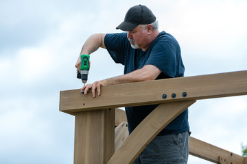 Mature man building wooden construction - 208936247