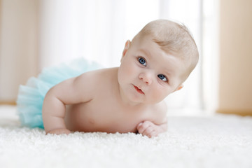 Adorable baby girl on white background wearing turquoise tutu skirt. © Irina Schmidt