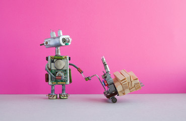 Robot moving powered pallet jack with wooden blocks. Forklift cart mechanism on pink wall, gray floor background. Copy space. Robotic automation delivery service transportation logistic concept