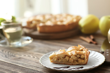 Plate with piece of tasty homemade apple pie on wooden table