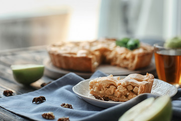 Plate with piece of tasty homemade apple pie on table