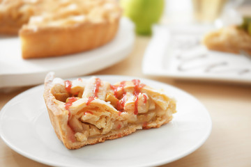 Plate with piece of tasty homemade apple pie on table
