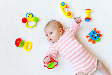 Cute baby girl playing with colorful rattle toys