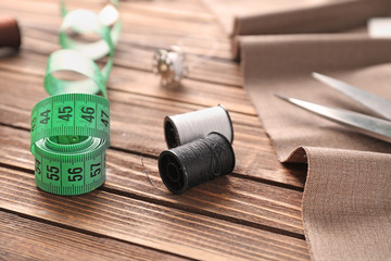 Fabric and sewing accessories on wooden background