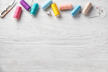 Sewing accessories on white wooden background