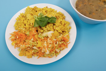 Baked Bulgar with cauliflower and vegetable salad on a blue