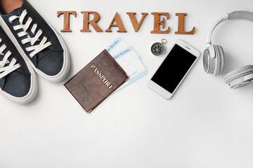 Composition with passport, immigration bureau cards, smartphone and word "Travel" on white background