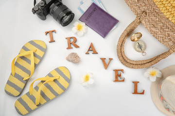 Composition with passport, photo camera, compass and word "Travel" on white background
