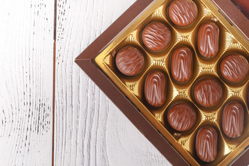 chocolate candies in box, close up view on white table