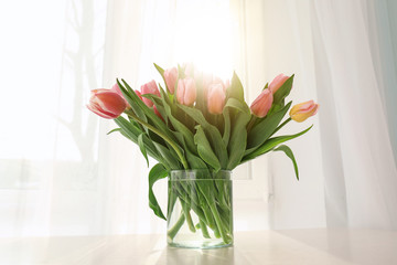 Fototapeta na wymiar Vase with beautiful tulips on windowsill