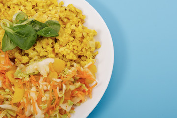 Baked Bulgar with cauliflower and vegetable salad on a blue