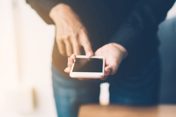 Woman hands using smartphone searching or social networks concept, hipster man typing an sms message to his friends while working Communication without borders