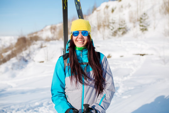 Photo of sporty woman with skis and sticks in winter