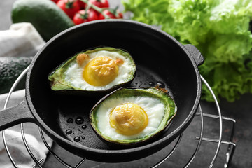Baked avocado with eggs in frying pan