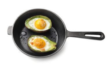 Baked avocado with eggs in frying pan on white background