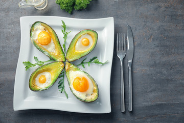 Baked avocados with eggs on table