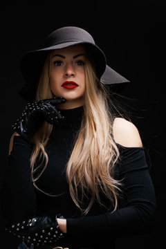 Portrait of young blonde in hat , gloves
