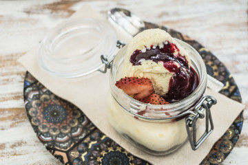 Vanilla and strawberry ice cream on a white wooden table