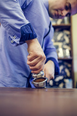 Portrait of barista man with mortar with coffee in hands
