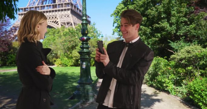 A man takes picture of his pretty girlfriend near the Eiffel Tower, Loving tourist couple in Paris, 4k