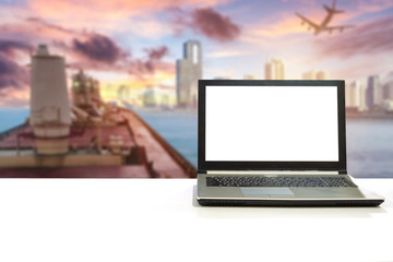 Laptop on white desk with blurred scene cargo shipping with plane export to city
