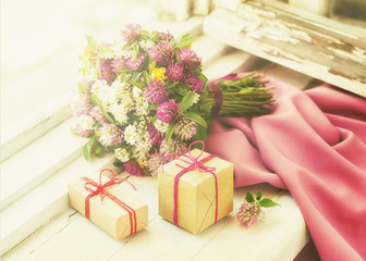 A bouquet of wild flowers and packed gifts on the windowsill.