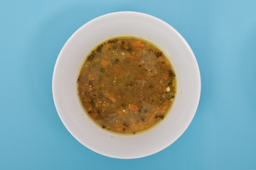 Lentil soup with carrot on a blue