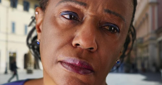 Close up of mature black woman looking off in the distance, Portrait of older African American woman looking mournfully off camera, 4k