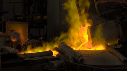 Hot steel pouring at steel plant. In the frame, molten metal is poured through special channels, for the further rolling with a special machine. Modern metallurgical industry