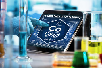 researcher consulting on the digital tablet data of the chemical element Cobalt Co / scientist...