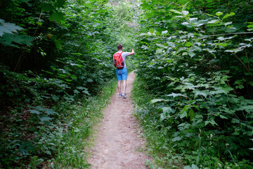 young attractive sporty man walking along a path in the forest