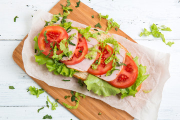 baguette sandwich with ham, tomatoes and lettuc