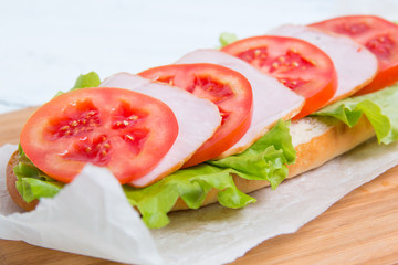 baguette sandwich with ham, tomatoes and lettuc