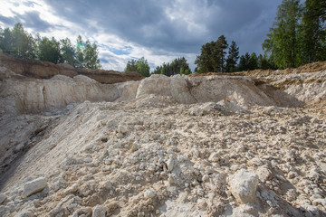 Open pit quarry ore white kaoline mining with blue sky and water
