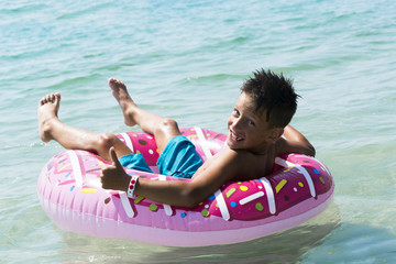 Child with inflatable ring in sea © alexytrener