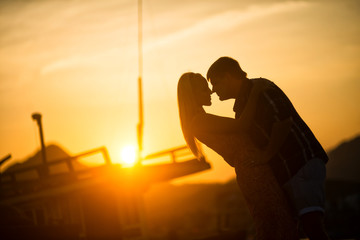 Fototapeta na wymiar man and woman kissing at sunset. Silhouette photo