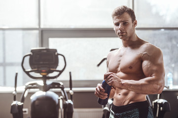 handsome strong bodybuilder athletic men pumping up muscles with dumbbells
