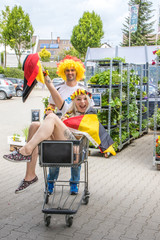 Pärchen als Fußballfans feiern auf Supermarkt Parkplatz den Sieg der deutschen Nationalmannschaft