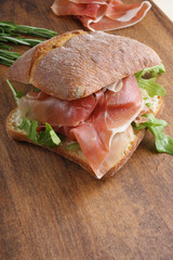 sandwich with prosciutto jamon on a wooden background