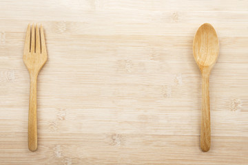 Spoon and fork wooden isolated on the wood table background with copy space for text. Creative layout for business food concept.