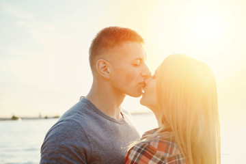 couple happy on the beach sunset romantic kiss close-up