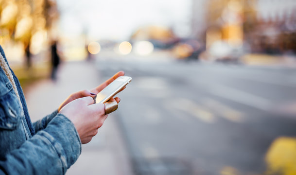 Close-up Image Of Female Hands Using Phone On The Street.